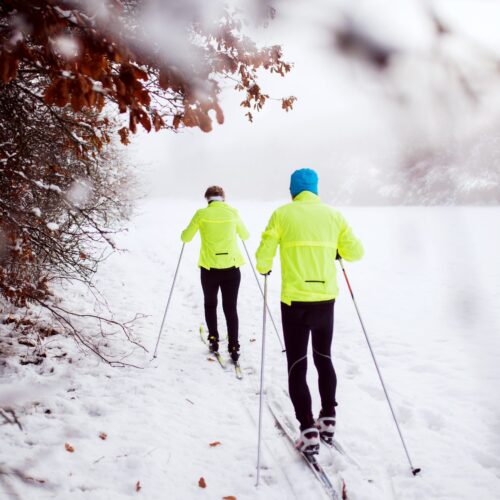 senior-couple-cross-country-skiing-PJNZDVU-scaled